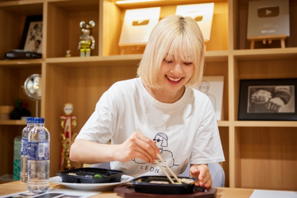 筋肉食堂DELIのコラボ商品を試食している美月さん